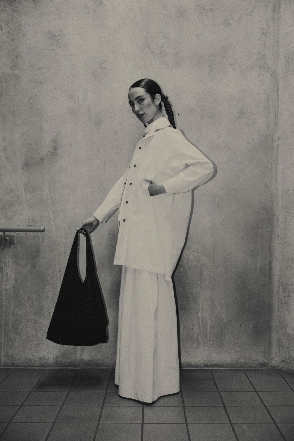 Female wearing a black organic cotton bag. Atelier Tote in black by September Archive. Photograph by Trevor Brady.