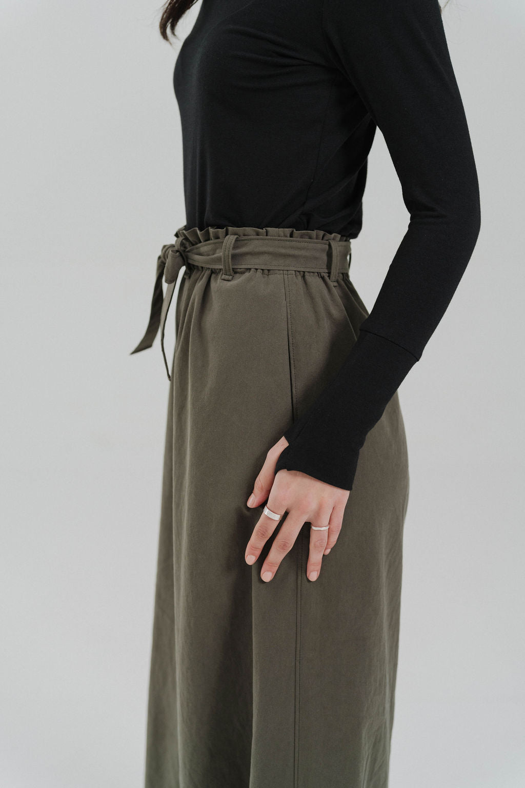 Comfy black long sleeve shirt worn by a female. Close up of the thumb hole detail. Eco friendly knit shirt. Thumbs up Knit Long Sleeve Shirt in black by September Archive. Photographed by Paper Crane Creative.