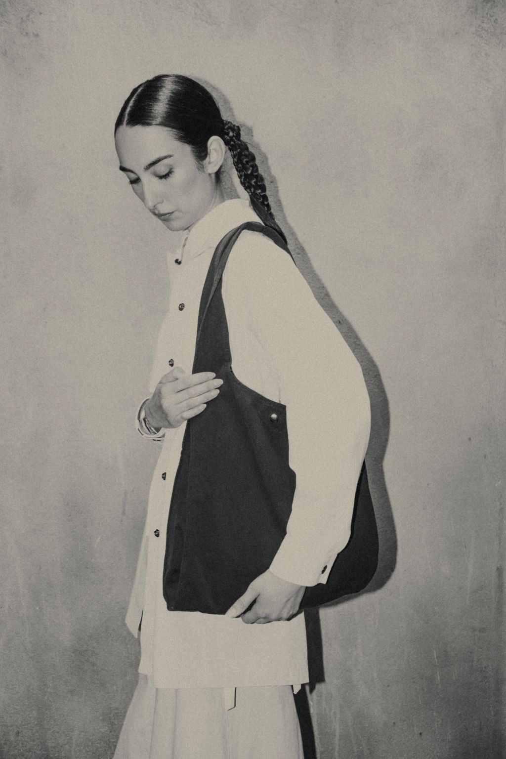 Female wearing a black organic cotton bag. Atelier Tote in black by September Archive. Photograph by Trevor Brady.