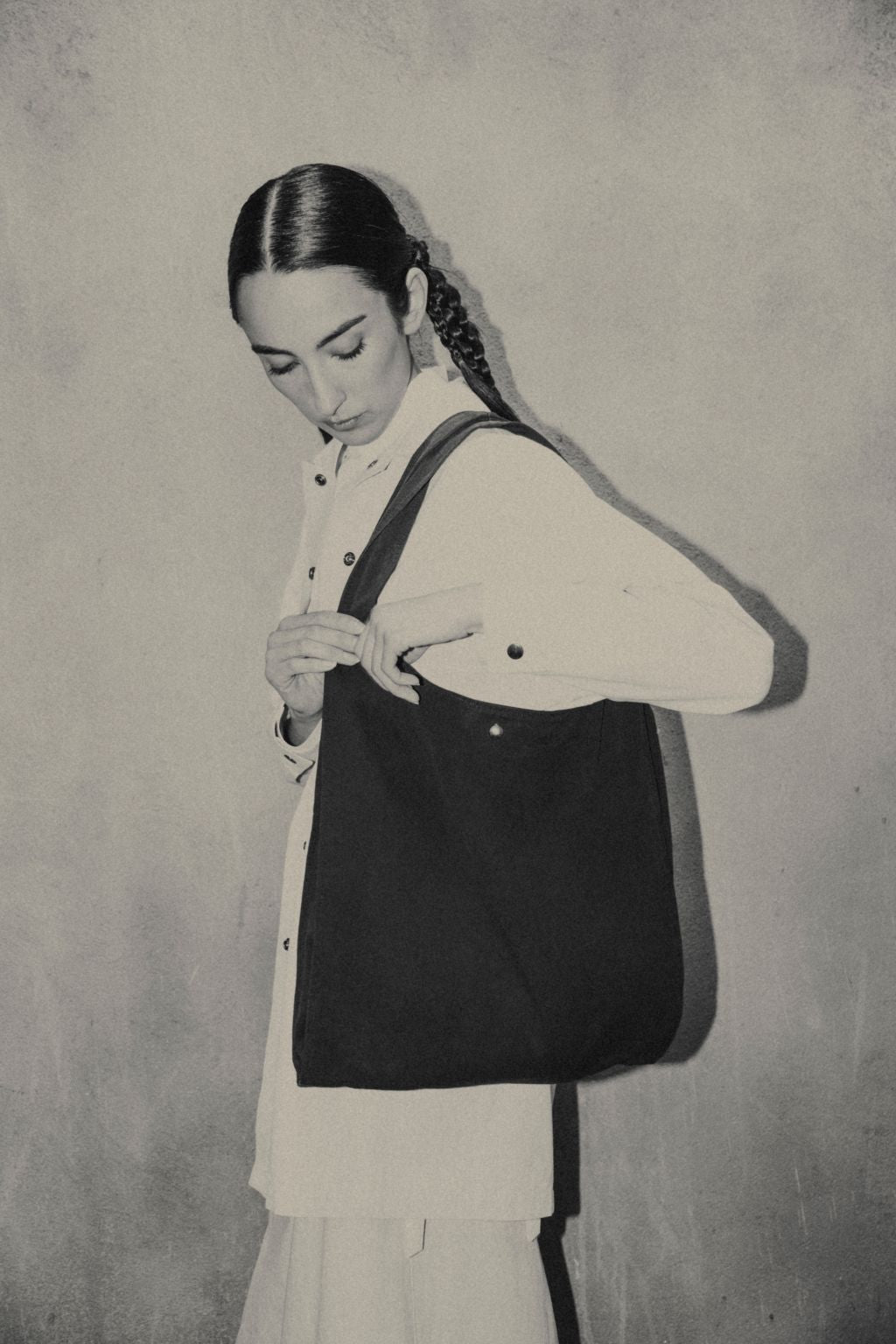 Female wearing a black organic cotton bag. Atelier Tote in black by September Archive. Photograph by Trevor Brady.