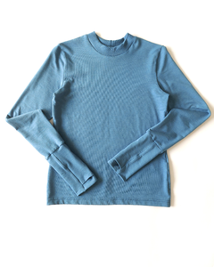 A flat lay of an organic comfy vibrant blue long sleeve shirt. Thumbs up Knit Long Sleeve Shirt in Stellar Sky by September Archive. Photographed by Sheila Wong.